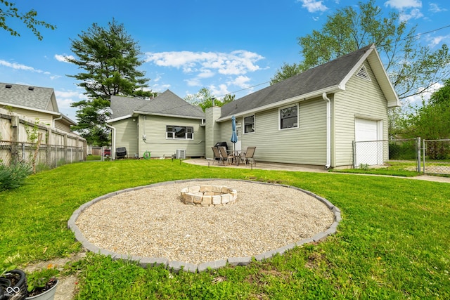 back of house featuring a patio area, fence, an outdoor fire pit, a yard, and an attached garage