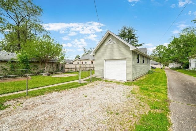 garage with fence and gravel driveway