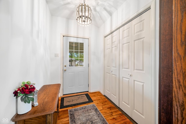 doorway to outside featuring wood finished floors and a chandelier
