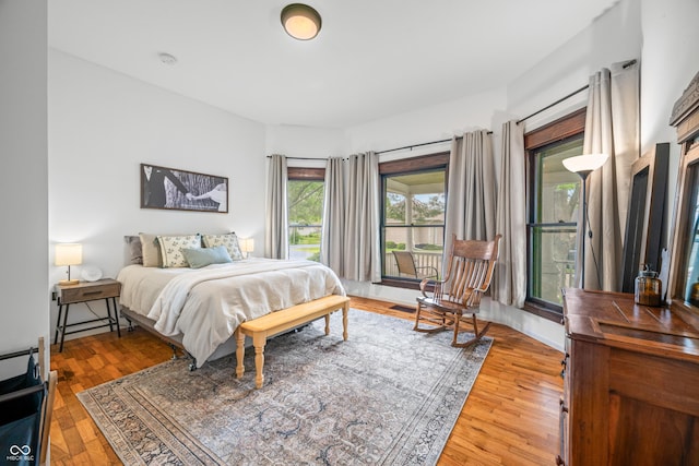 bedroom featuring access to outside and wood finished floors