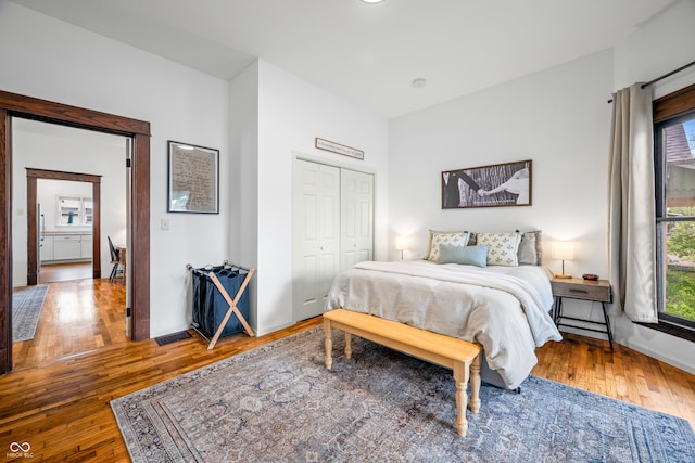 bedroom featuring baseboards, wood finished floors, and a closet