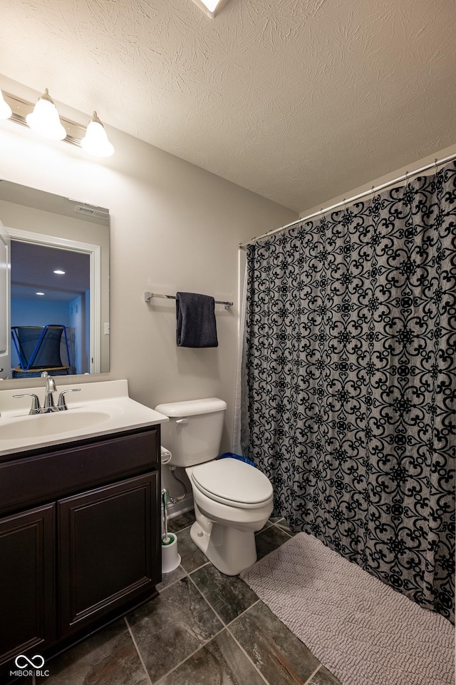 full bath with vanity, a textured ceiling, curtained shower, and toilet