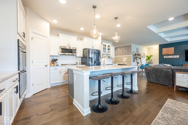 kitchen featuring tasteful backsplash, stainless steel appliances, dark wood-style floors, and white cabinets