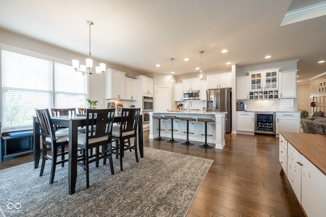 dining room with wine cooler, recessed lighting, dark wood-style floors, and a notable chandelier