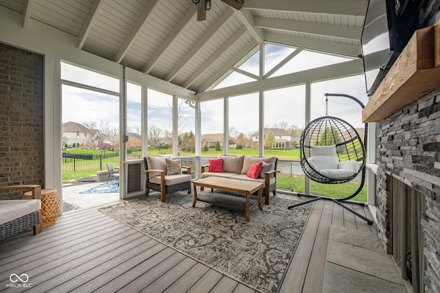 sunroom / solarium featuring a ceiling fan, a residential view, a healthy amount of sunlight, and an outdoor hangout area