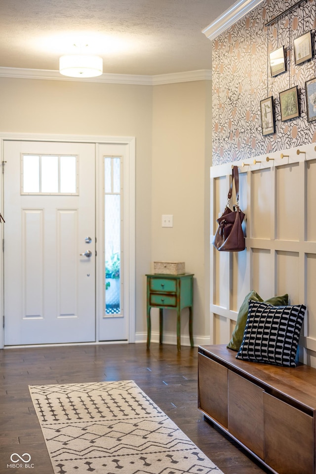 foyer entrance with baseboards, ornamental molding, and wood finished floors