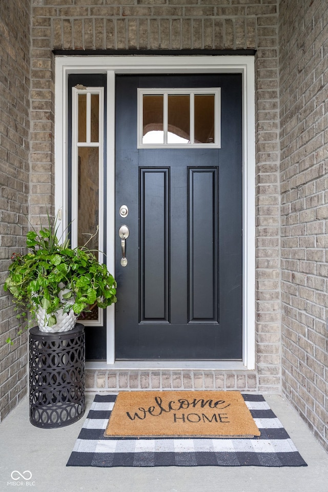view of exterior entry with brick siding
