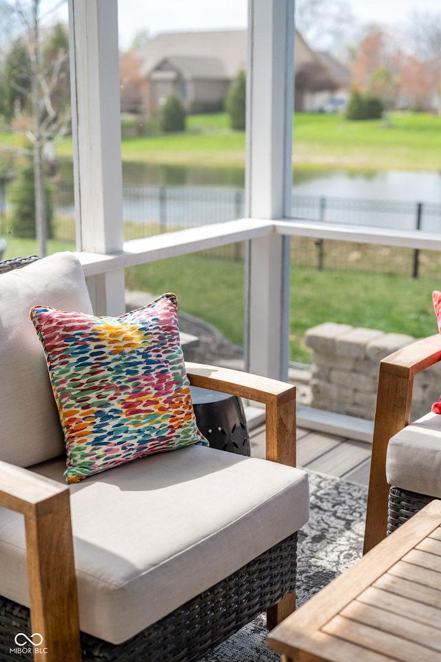 sunroom featuring a water view