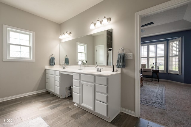 full bath featuring double vanity, a sink, and a wealth of natural light
