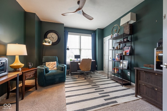 office space with carpet floors, a ceiling fan, and baseboards