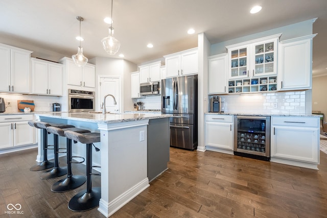 kitchen featuring wine cooler, decorative backsplash, stainless steel appliances, and white cabinets