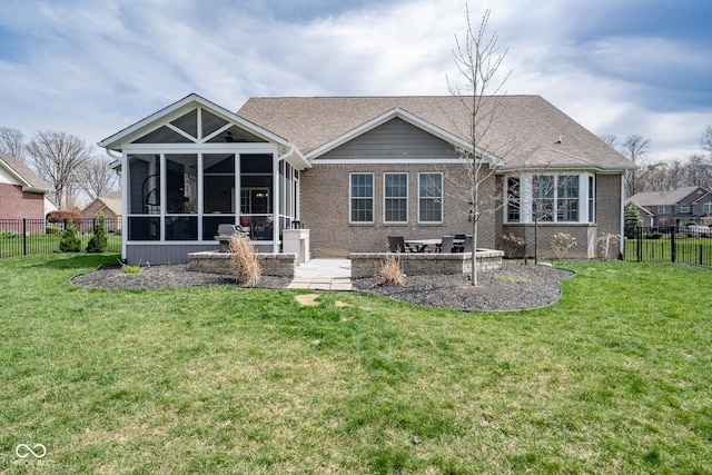 rear view of property with a sunroom, a fenced backyard, a yard, and brick siding
