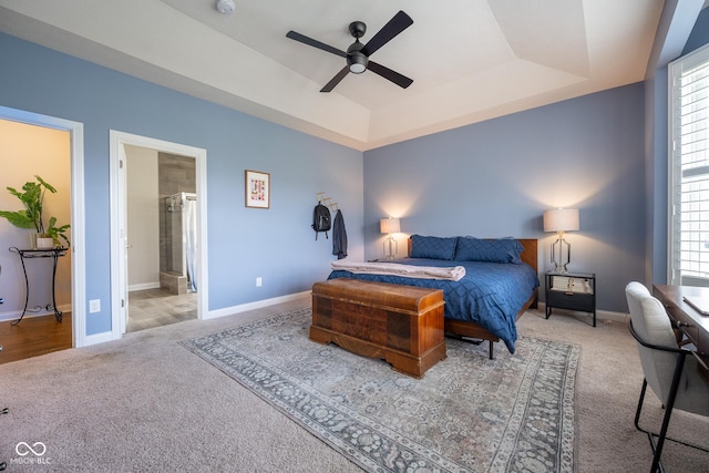 carpeted bedroom featuring baseboards, a tray ceiling, and multiple windows