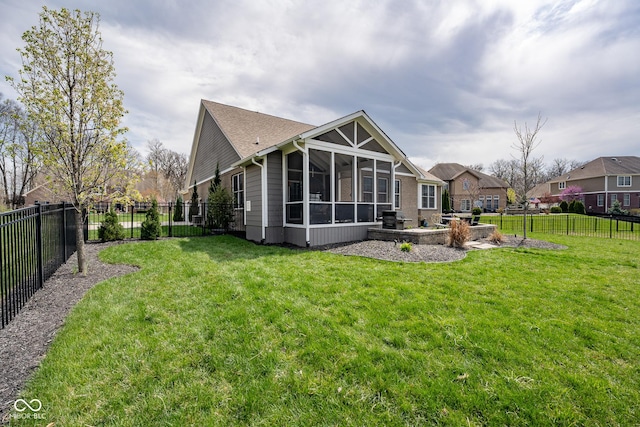 rear view of house with a sunroom, a fenced backyard, and a yard