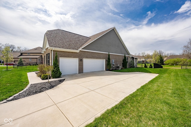 view of side of home featuring a lawn, a garage, a shingled roof, and concrete driveway