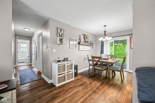 dining area with an inviting chandelier, baseboards, and wood finished floors