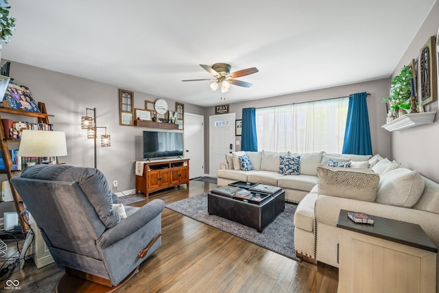 living area with ceiling fan and dark wood-type flooring
