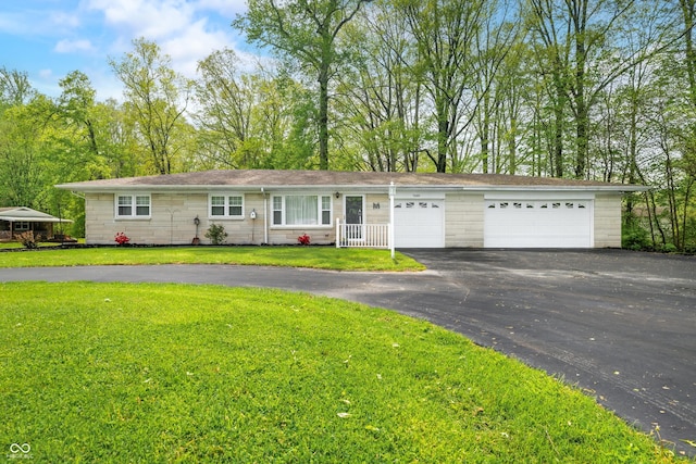 single story home with stone siding, driveway, a front yard, and a garage
