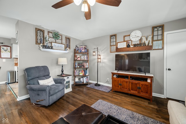 living area with baseboards, a ceiling fan, and wood finished floors
