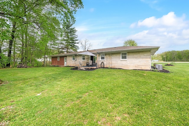 rear view of property with a patio, cooling unit, a yard, and stone siding