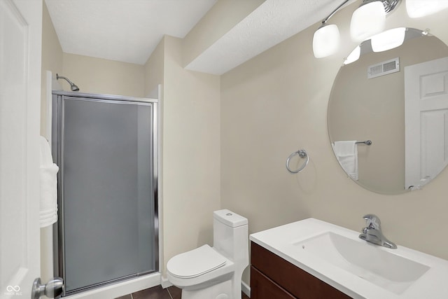 bathroom featuring a stall shower, toilet, vanity, and tile patterned flooring