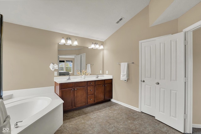 full bathroom featuring vaulted ceiling, a garden tub, double vanity, and baseboards