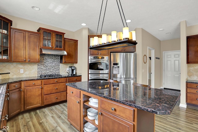 kitchen with stainless steel appliances, light wood-type flooring, under cabinet range hood, a center island, and recessed lighting
