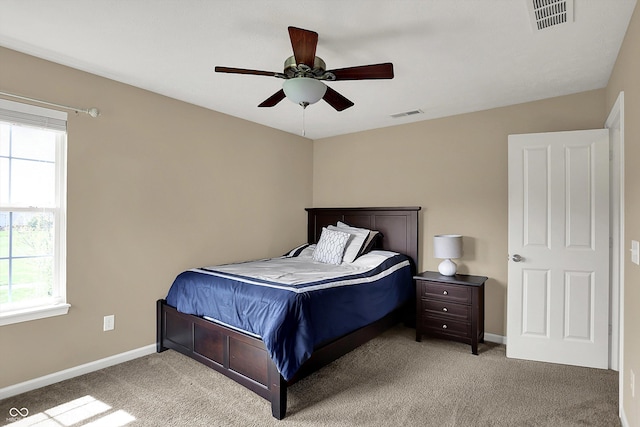 bedroom with multiple windows, light carpet, baseboards, and a ceiling fan