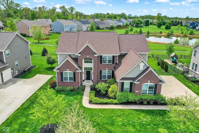 view of front of home with brick siding, a water view, and a residential view