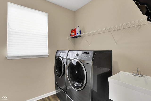 laundry room with washing machine and dryer, dark wood finished floors, and baseboards