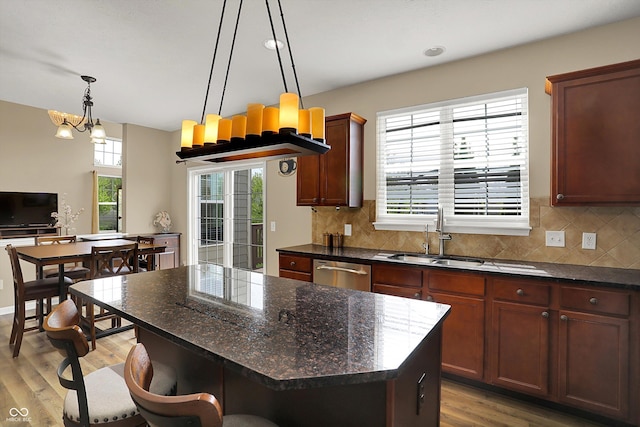 kitchen featuring dishwasher, a sink, a chandelier, backsplash, and recessed lighting