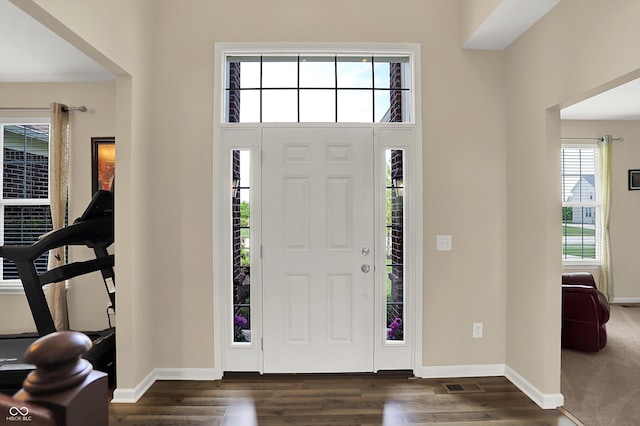 foyer with baseboards and dark wood-style floors