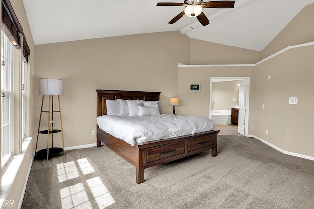 bedroom with carpet flooring, baseboards, high vaulted ceiling, ensuite bath, and a ceiling fan