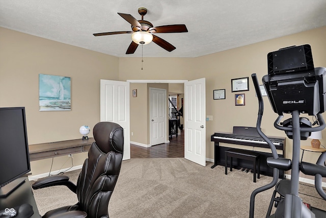 carpeted home office featuring a ceiling fan and baseboards