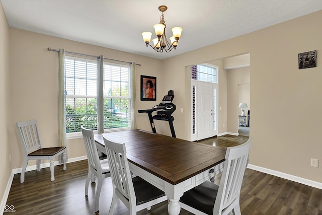 dining area featuring a chandelier, dark wood-type flooring, and baseboards