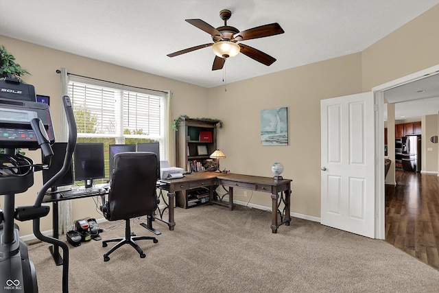 office area featuring a ceiling fan, baseboards, and carpet