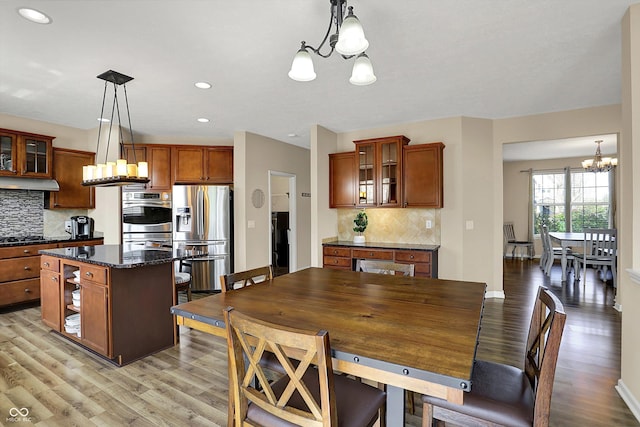 dining space featuring a chandelier, light wood finished floors, recessed lighting, and baseboards