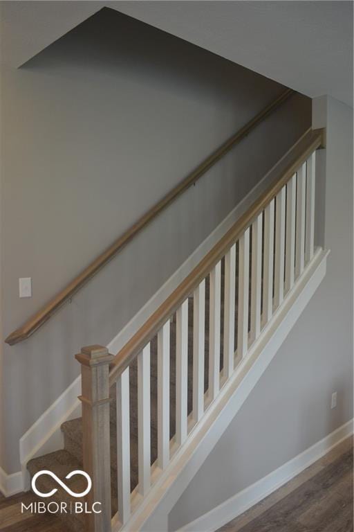 staircase featuring baseboards and wood finished floors
