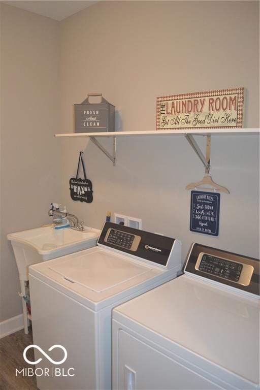 laundry area featuring laundry area, baseboards, washing machine and dryer, and wood finished floors