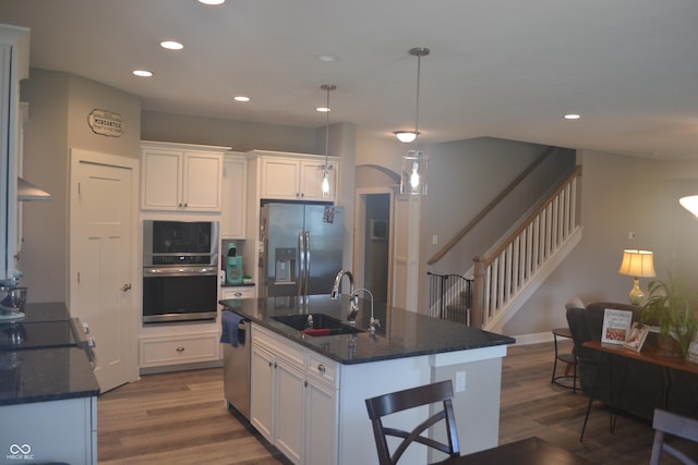 kitchen featuring white cabinets, appliances with stainless steel finishes, a sink, and dark wood finished floors