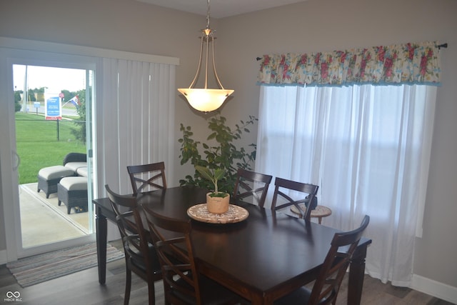 dining room featuring plenty of natural light, baseboards, and wood finished floors