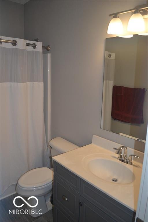 bathroom with vanity, a shower with shower curtain, and toilet
