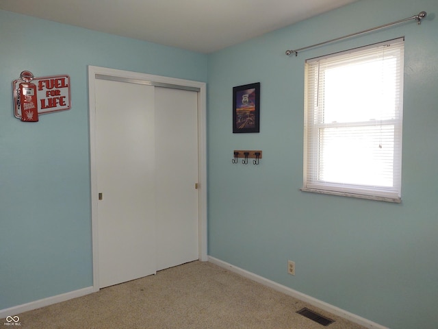 2630 Wedgewood Dr, Columbus, IN 47203 - unfurnished bedroom with light colored carpet, visible vents, multiple windows, and a closet