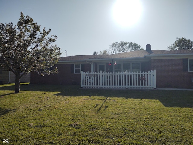 2630 Wedgewood Dr, Columbus, IN 47203 - view of front of home with brick siding, a chimney, a front yard, and fence