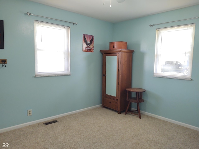 2630 Wedgewood Dr, Columbus, IN 47203 - carpeted empty room featuring baseboards, a wealth of natural light, ceiling fan, and visible vents