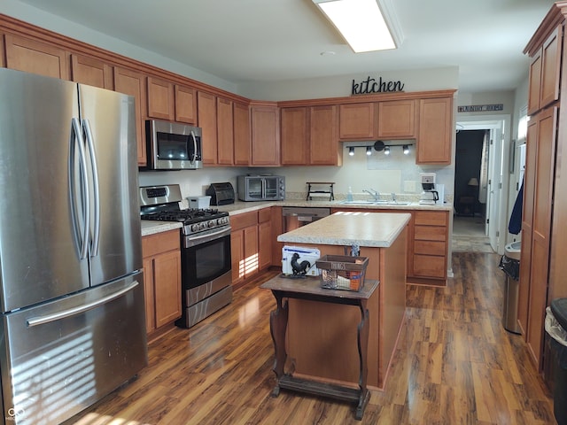 2630 Wedgewood Dr, Columbus, IN 47203 - kitchen featuring a kitchen island, a sink, light countertops, dark wood-style floors, and stainless steel appliances