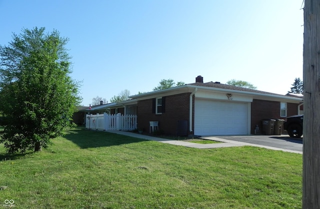 2630 Wedgewood Dr, Columbus, IN 47203 - view of side of property with a yard, brick siding, driveway, and a garage