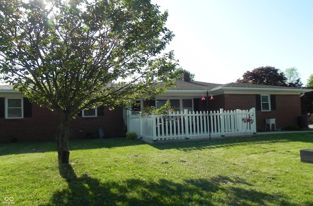 2630 Wedgewood Dr, Columbus, IN 47203 - view of front facade with fence, a chimney, a front lawn, and brick siding