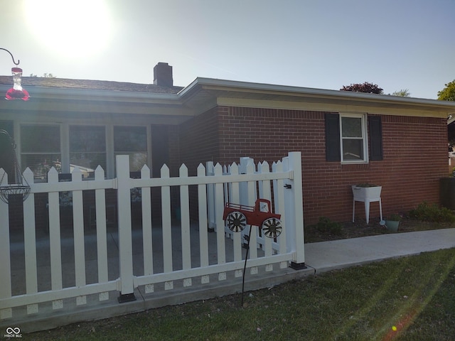 2630 Wedgewood Dr, Columbus, IN 47203 - view of property exterior featuring brick siding, fence, and a chimney
