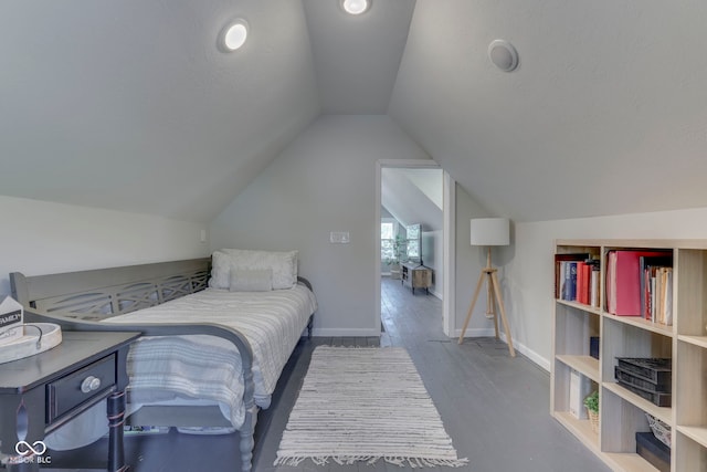 bedroom with baseboards, vaulted ceiling, and wood finished floors